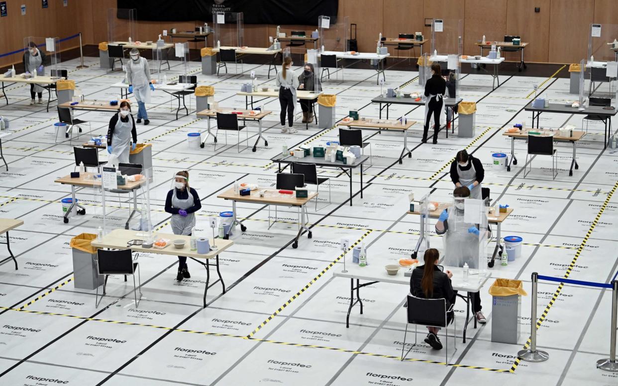 Students at Hull University take swabs for lateral flow Covid-19 tests at the campus sports facilities on January 4, - PAUL ELLIS/AFP