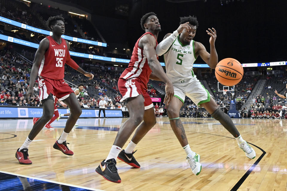 Washington State guard TJ Bamba, center and Oregon guard Jermaine Couisnard (5) chase the ball during the second half of an NCAA college basketball game in the quarterfinals of the Pac-12 Tournament, Thursday, March 9, 2023, in Las Vegas. (AP Photo/David Becker)