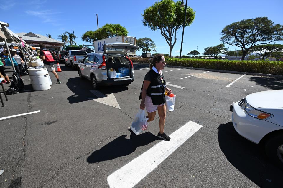 Volunteers work to hand out food, water and other essentials to residents as response to the Maui fire that destroyed a large portion of the town of Lahaina, Hawaii, continues to come from neighboring islands and the mainland on Thursday, Aug. 17, 2023. | Scott G Winterton, Deseret News