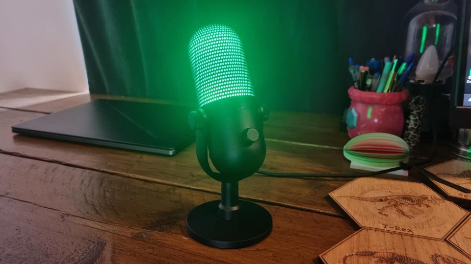 The Razer Seiren V3 Chroma lit up in green on a desktop