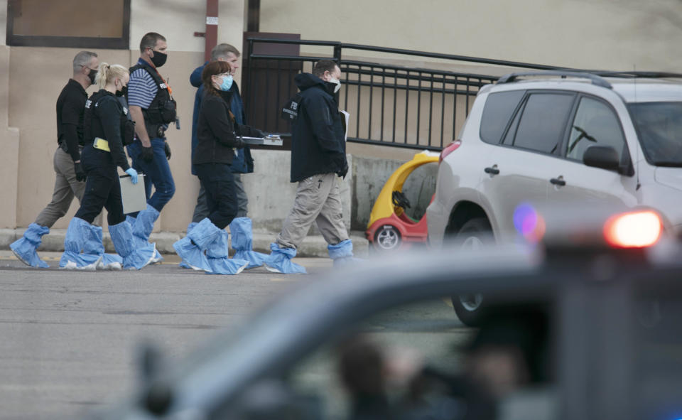 Police wearing forensic shoe covers at the scene of the Boulder shooting.