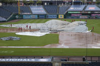 Grounds crew tries to untangle the tarp as they attempt to cover the baseball diamond from a heavy downpour delaying the baseball game during the sixth inning of a baseball game between the Washington Nationals and the Baltimore Orioles in Washington, Sunday, Aug. 9, 2020. (AP Photo/Manuel Balce Ceneta)