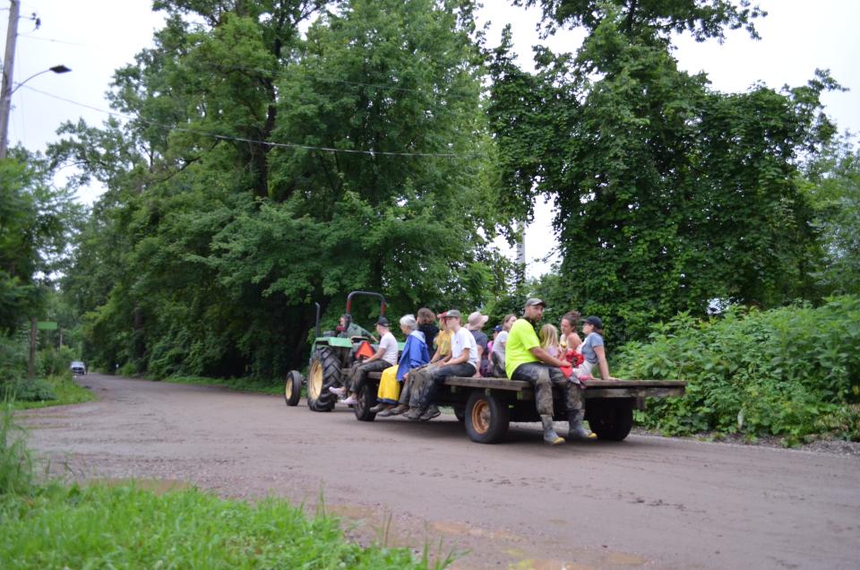 Volunteers catch a ride on a tracker on the way back to the Intervale Center from the farms. They were out helping move crops before the fields flooded from the raising waters of the Winooski River Thursday, July 11, 2024.