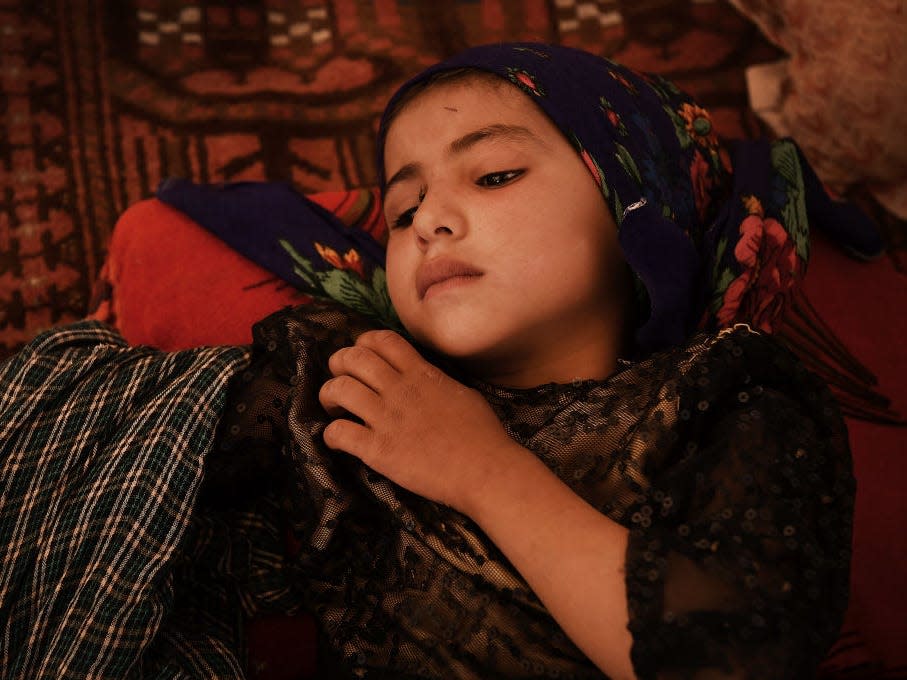 Four-year-old Khadija lies in her family’s temporary shelter in the Regreshan IDP camp in Herat Province, Afghanistan, June 17, 2019. Her father, Abdul Haq, agreed to sell her to a money lender to pay off his debts. The money lender intended to give Khadija to his 15-year-old son to be his child bride. Abdul reneged on the agreement and is still attempting to pay his debts. (Photo by Kate Geraghty/Fairfax Media via Getty Images via Getty Images)