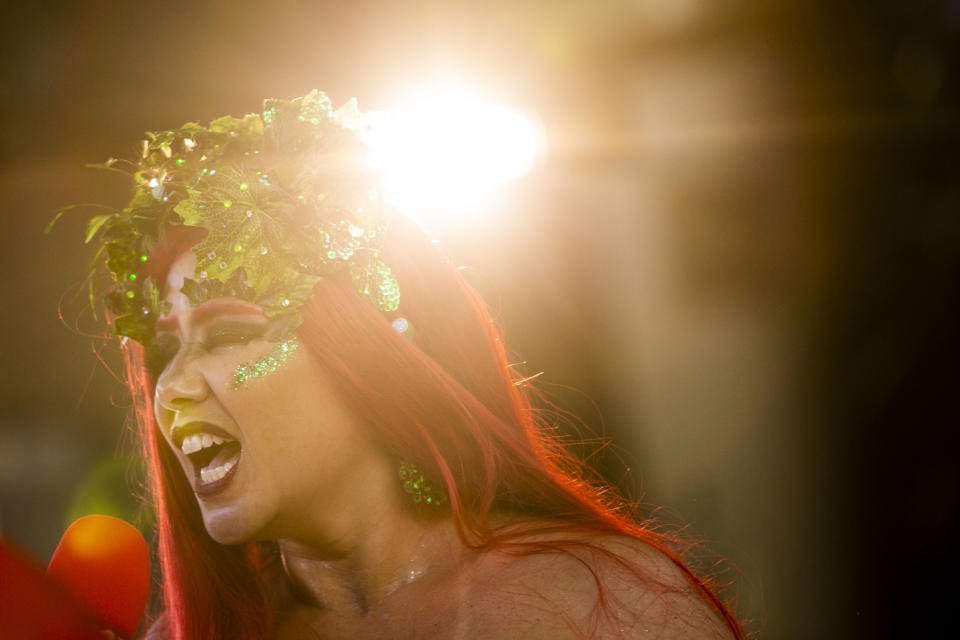 A woman performs in the "Desliga da Justica" street band in Rio de Janeiro, Brazil, Sunday, Feb. 14, 2021. Their performance was broadcast live on social media for those who were unable to participate in the carnival due to COVID restrictions after the city's government officially suspended Carnival and banned street parades or clandestine parties. (AP Photo/Bruna Prado)