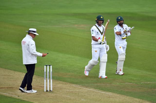 Pakistan’s Mohammad Rizwan and Naseem Shah leave the pitch for bad light as the umpire takes a light reading 