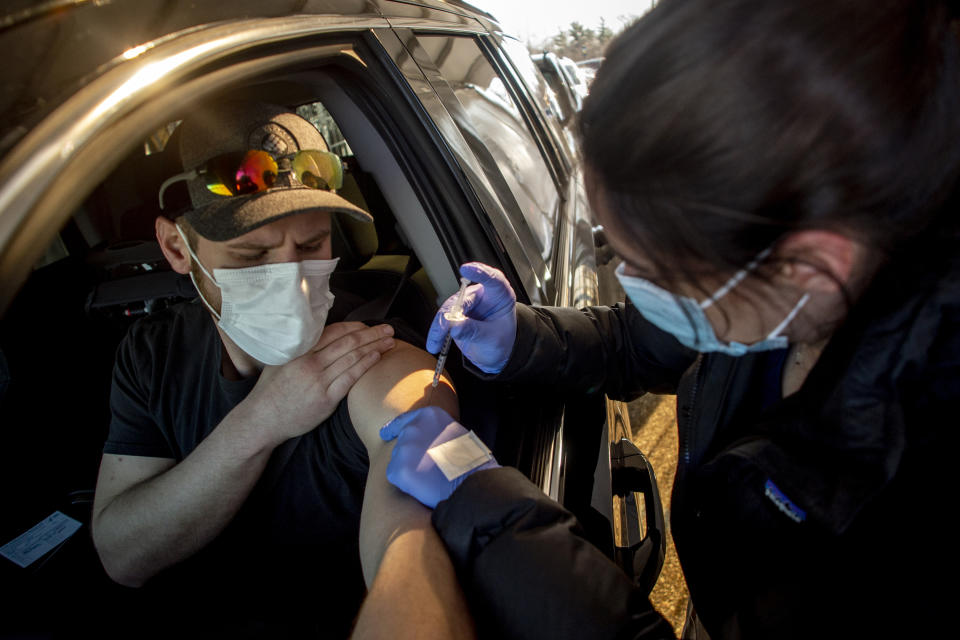 FILE - In this March 29, 2021, file photo, UM-Flint nursing student Michaela Dimello gives Burton resident John Ray his first dose of the Moderna COVID-19 vaccine at Bishop Airport in Flint, Mich. The Genesee County Health Department continues to facilitate the vaccination of local residents. (Jake May/The Flint Journal via AP, File)