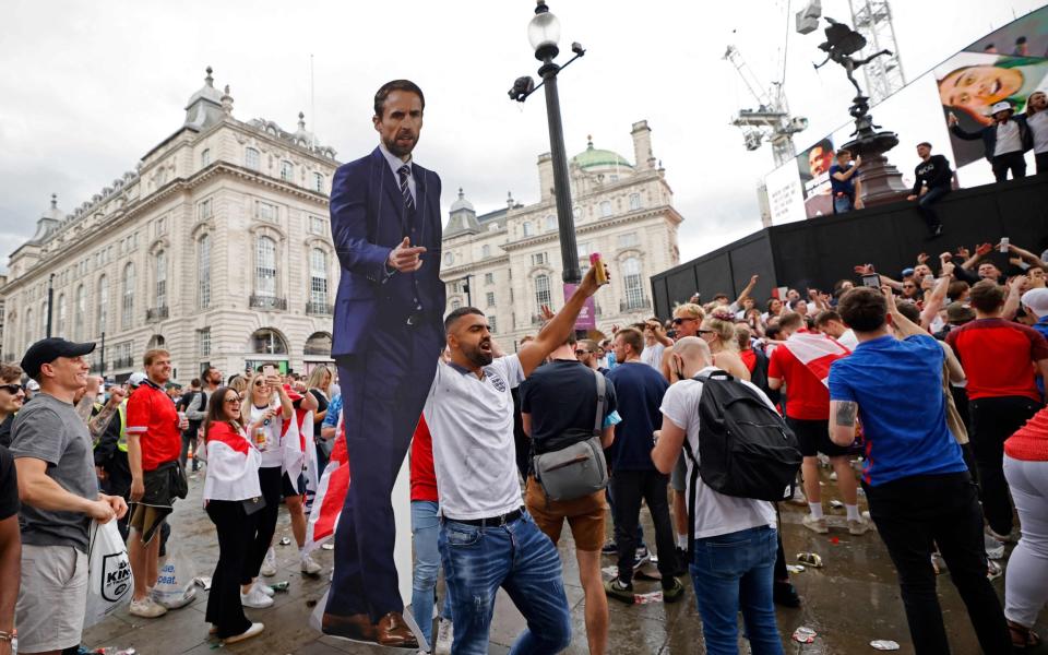 A lifesize cut out of England's manager Southgate is held aloft as supporters gather in Piccadilly Circus ahead of the final - Tolga Akmen/AFP