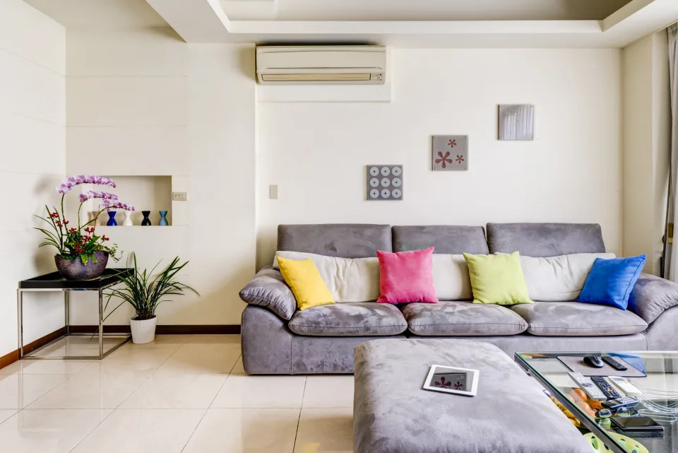 An empty living room with comfortable sofa and different colors of pillows