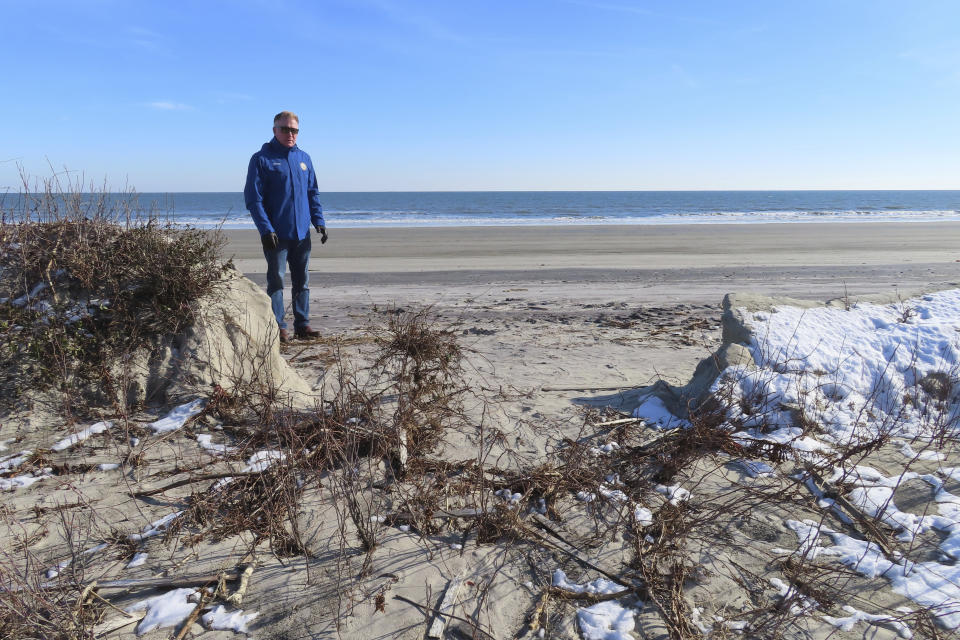 Mayor Patrick Rosenello stands next to a destroyed section of sand dune in North Wildwood N.J. on Jan. 22, 2024. A recent winter storm punched a hole through what is left of the city's eroded dune system, leaving it more vulnerable than ever to destructive flooding as the city and state fight in court over how best to protect the popular beach resort. (AP Photo/Wayne Parry)