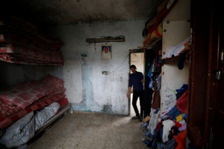 A Palestinian man stands in a house in the northern Gaza Strip February 12, 2018. Picture taken February 12, 2018. REUTERS/Mohammed Salem