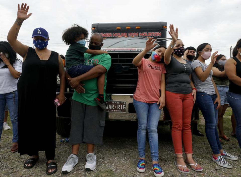 People raise their hands during a moment of prayer at a vigil for Guillén on 5 July in Houston.