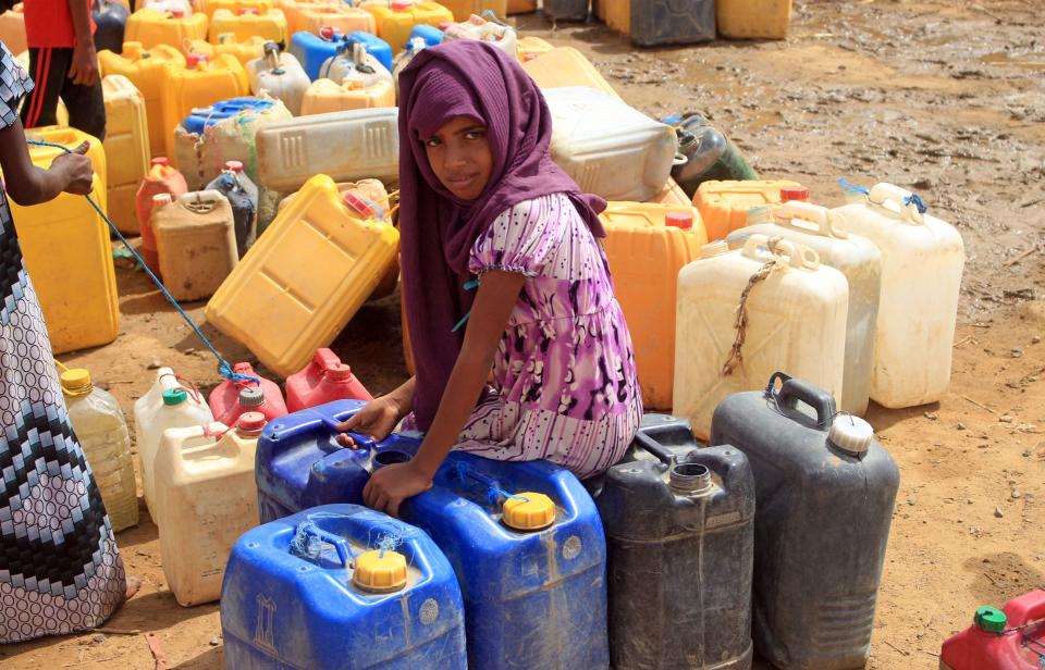 A Yemeni girl waits as others fill their jerrycans with water at a makeshift camp for the internally displaced, in the northern Hajjah province on June 4, 2022, amid a severe heat wave and acute water shortage. / Credit: Essa Ahmed/AFP via Getty Images