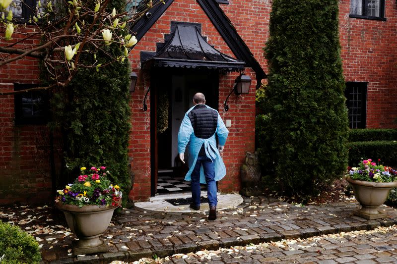 Dr Greg Gulbransen dons personal protective gear for a home call with a patient who had earlier been confirmed to have the coronavirus disease (COVID-19) as he maintains visits with both his regular patients and those with the virus in Oyster Bay, New York