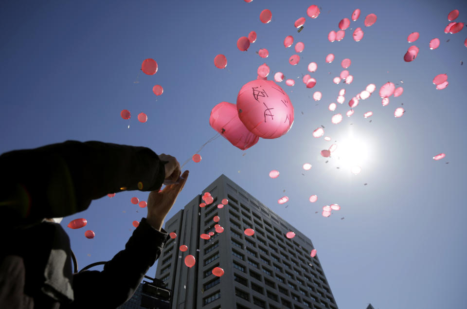 Anti-nuclear protesters release balloons during a rally in front of the Ministry of Economy, Trade and Industry (METI) in Tokyo, Tuesday, March 11, 2014. METI governs Japan's Nuclear and Industrial Safety Agency and is responsible for promoting nuclear power. Japan on Tuesday marks the third anniversary of the March 11, 2011 earthquake and tsunami that killed 15,884 people and left more than 2,600 unaccounted for in vast areas of its northern coast. The writing on the balloon reads " Fukushima Return." (AP Photo/Eugene Hoshiko)