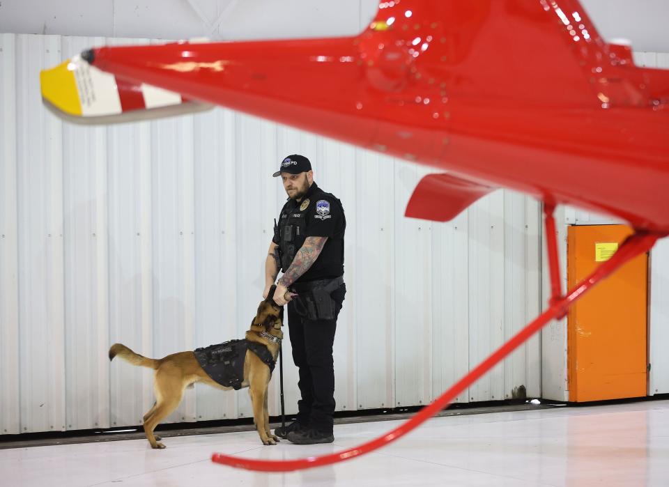 Brigham City Officer Kyle Whitaker and his dog Rocco stand near a helicopter at Intermountain Life Flight hangar in Salt Lake City on Tuesday, Feb. 20, 2024. Collaboration with local veterinarians, specialized animal hospitals and public safety agencies, Intermountain Life Flight is launching a specialized K9 air transport service for public agency service animals who are injured in the line of duty. | Jeffrey D. Allred, Deseret News