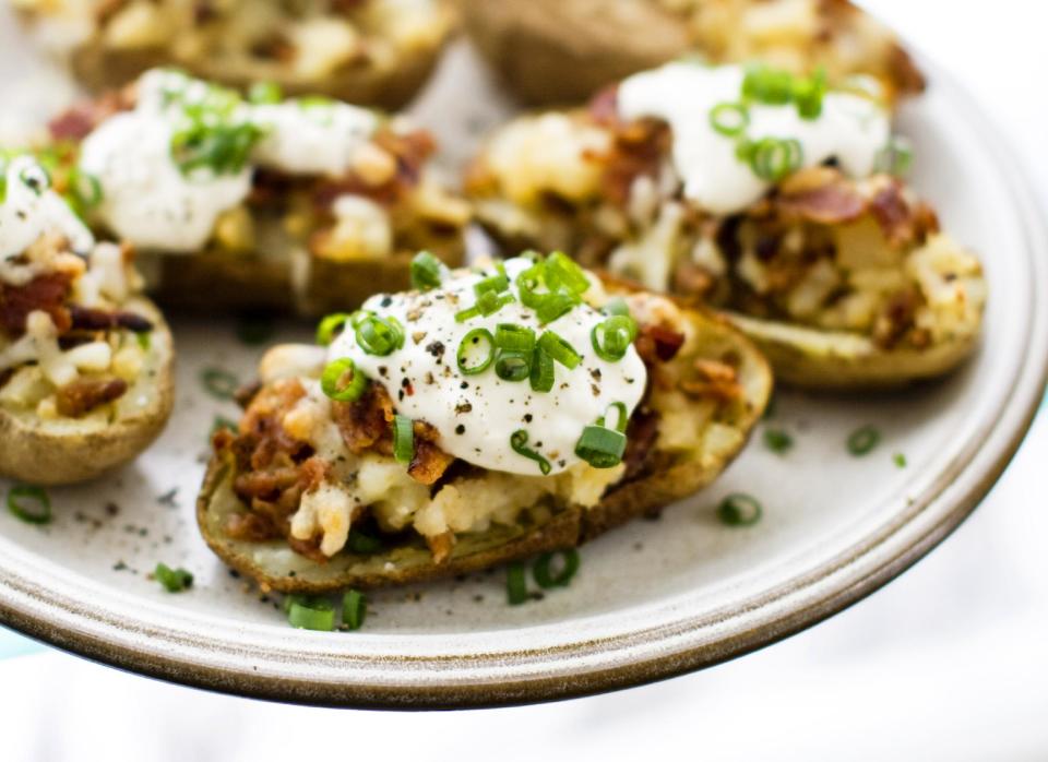 This Jan. 6, 2014 photo shows seven layer potato skins in Concord, N.H. Everybody seems enraptured by seven-layer dip. So for this year’s Super Bowl party, why not freshen it up a bit? Take the same concept of shoveling piles of delicious toppings into your mouth, but instead of chips use a slab of roasted potato. (AP Photo/Matthew Mead)