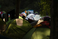 People stand next to their tents set up in a camp site Thursday, Aug. 22, 2019, in Urrugne, southwestern France. Various groups of protesters are setting up camps at towns near to the Spanish border, as they prepare for their G7 protest actions during the Aug. 24-26 gathering of major world democracies. (AP Photo/Emilio Morenatti)