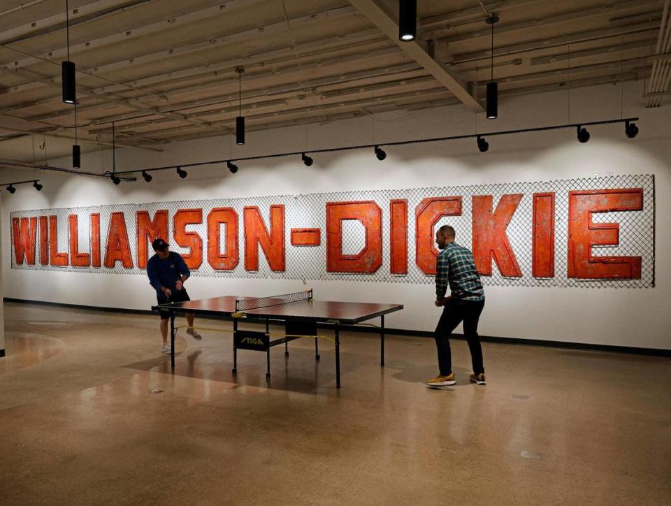 Dickies associates take a small work break in front of the original Williamson-Dickie sign at Dickies Quality Workwear and Apparel offices in downtown Fort Worth Texas, Thursday Mar. 28, 2024.