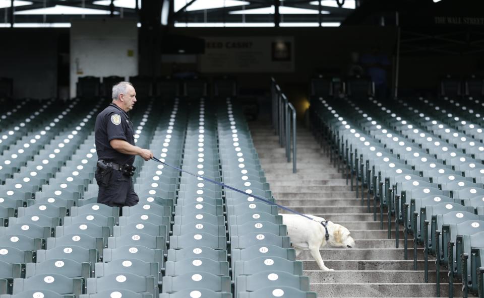 A Seattle Police Dept. K9 officer conducts a security sweep with his dog prior to a baseball game between the Seattle Mariners and the New York Mets, Tuesday, July 22, 2014 in Seattle. (AP Photo)