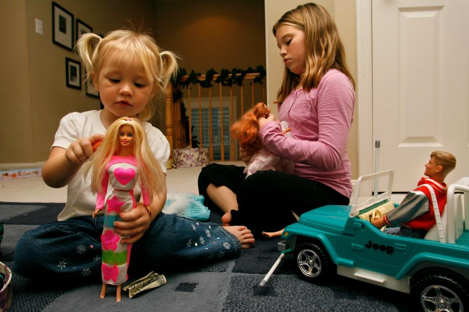 Aidia Bryant, 3, left, and her sister Cassidy Moock, 10, play with their Barbie dolls on Friday, Dec. 1, 2006 in Lorton, Va. "Barbies are awesome," says Cassidy, "they're like little people you get to dress yourself." Nearly 50 years after Mattel introduced her _ she has managed to thrive, especially in a time when classic toy makers have found themselves scrambling to attract new audiences. (AP Photo/Jacquelyn Martin)