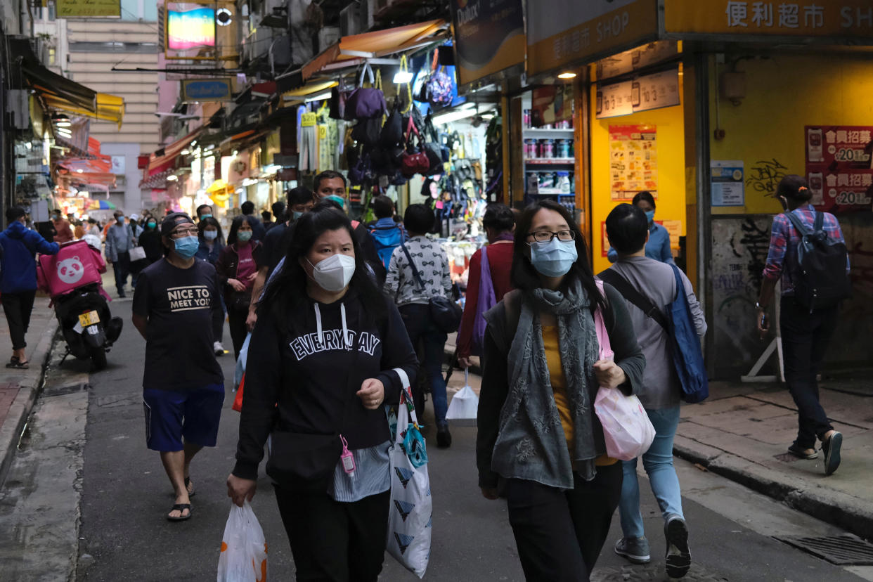 People with protective masks walk at a market, following the novel coronavirus disease (COVID-19) outbreak, in Hong Kong, China March 30, 2020. REUTERS/Tyrone Siu