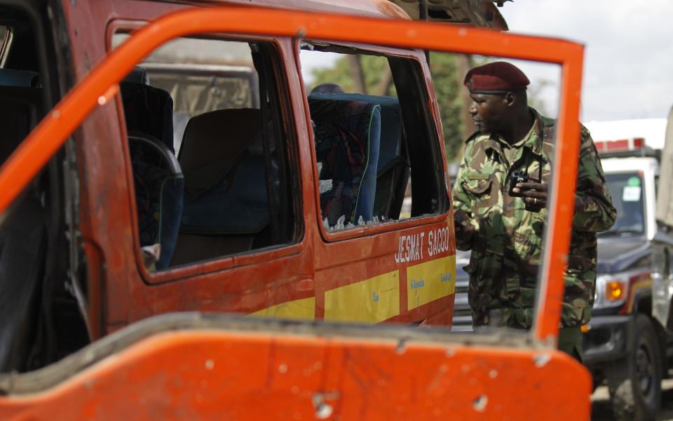 A policeman inspects a damaged public transport van at the scene of a twin explosion at the Gikomba open-air market for second-hand clothes in Kenya's capital Nairobi May 16, 2014. (REUTERS/Thomas Mukoya)