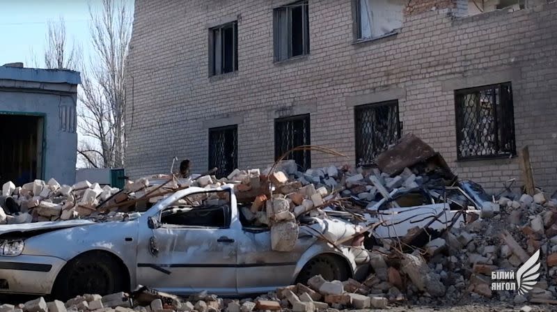FILE PHOTO: General view shows a car damaged by debris in Avdiivka