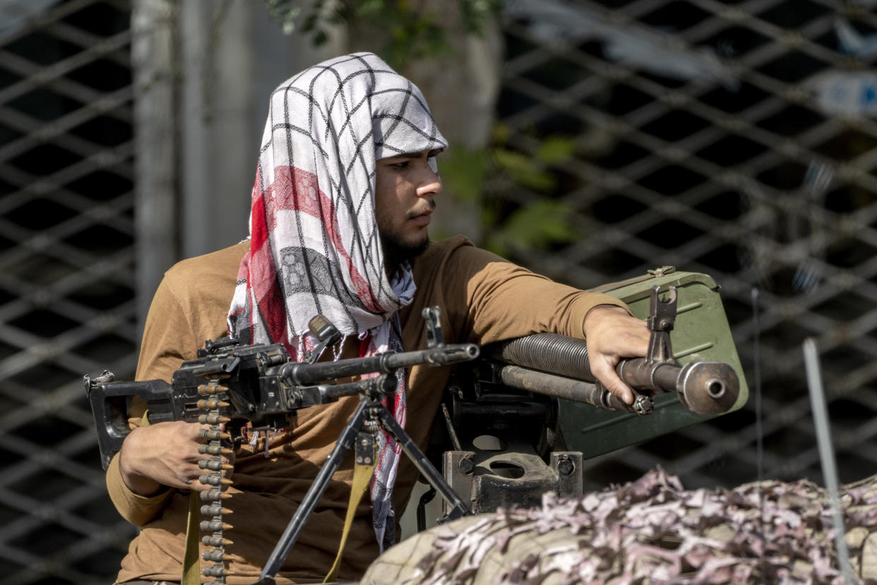 A Taliban fighter stands guard at the explosion site, near a mosque, in Kabul, Afghanistan, Friday, Sept. 23, 2022. An explosion went off near a mosque in Afghanistan's capital on Friday, with police confirming casualties. A column of black smoke rose into the sky and shots rang out several minutes after the blast in the city's diplomatic quarter. (AP Photo/Ebrahim Noroozi)