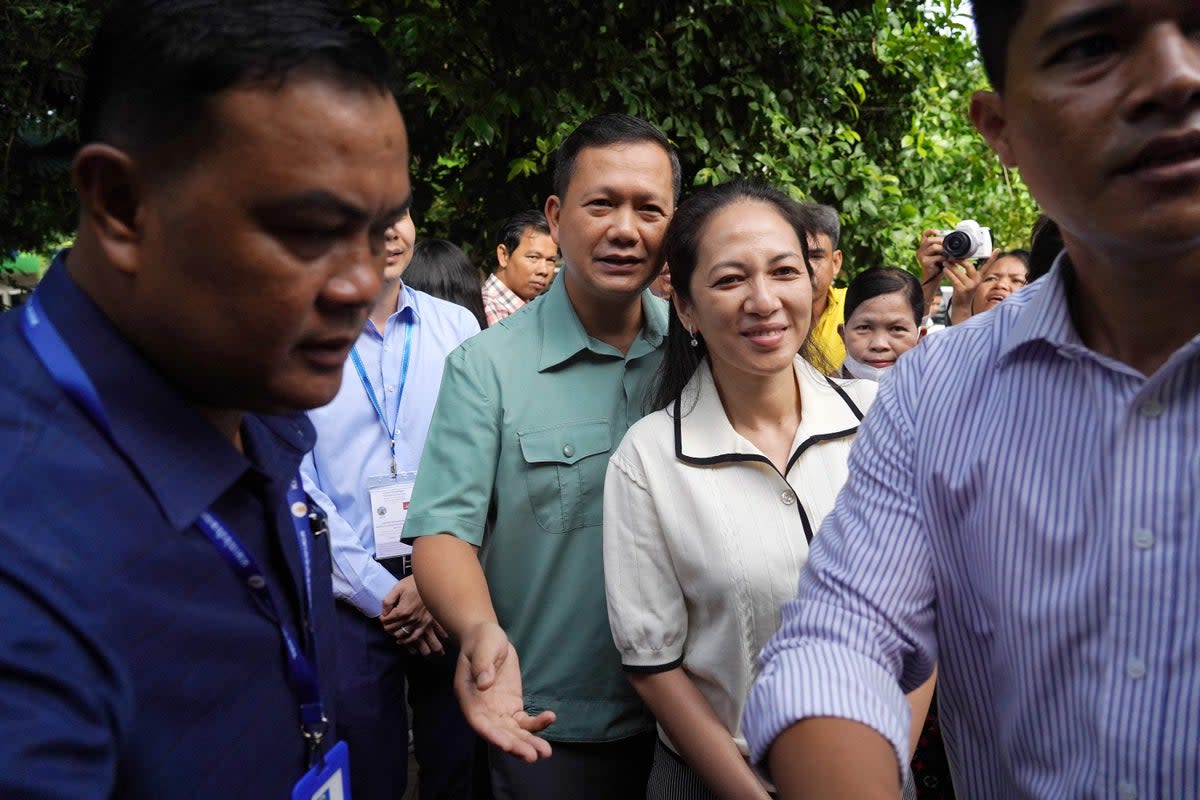 Hun Manet (Center-L), commander of the Royal Cambodian Army and eldest son of Prime Minister Hun Sen, with his wife Pich Chanmony (C) arrive at a polling station in Phnom Penh on 23 July, 2023 (AFP via Getty Images)