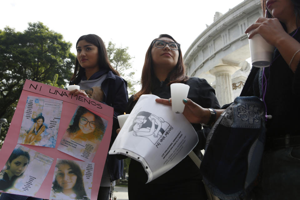 Women hold posters with photographs of victims during a tribute for murdered women, in the Alameda park of Mexico City, Saturday, Aug. 24, 2019. A small group of women constructed a memorial made of hand-knit hearts. The knit-in on came on the heels of rowdy protests sparked by outrage over bungled investigations into alleged rapes of teenagers by local policemen. (AP Photo/Ginnette Riquelme)