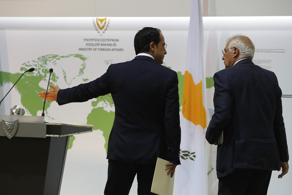 Cyprus' Foreign Minister Nikos Christodoulides shows the podium to the European Union's Foreign Policy Chief Josep Borrell, right, for a joint news conference at the Cypriot foreign ministry on Thursday, June 25, 2020. Borrell is in Cyprus to discuss developments in the EU's southeastern-most corner that borders a tumultuous region. (AP Photo/Petros Karadjias)