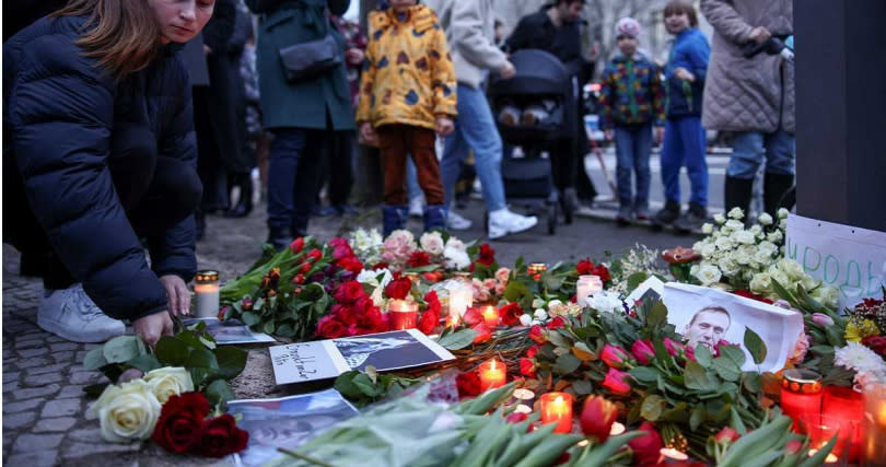 俄國反對派領袖納瓦尼死於監獄中，引發一連串後續效應，歐洲各國許多民眾前往俄羅斯駐該國大使館前抗議，手持鮮花或照片對納瓦尼表示哀悼。（圖／達志／路透社）