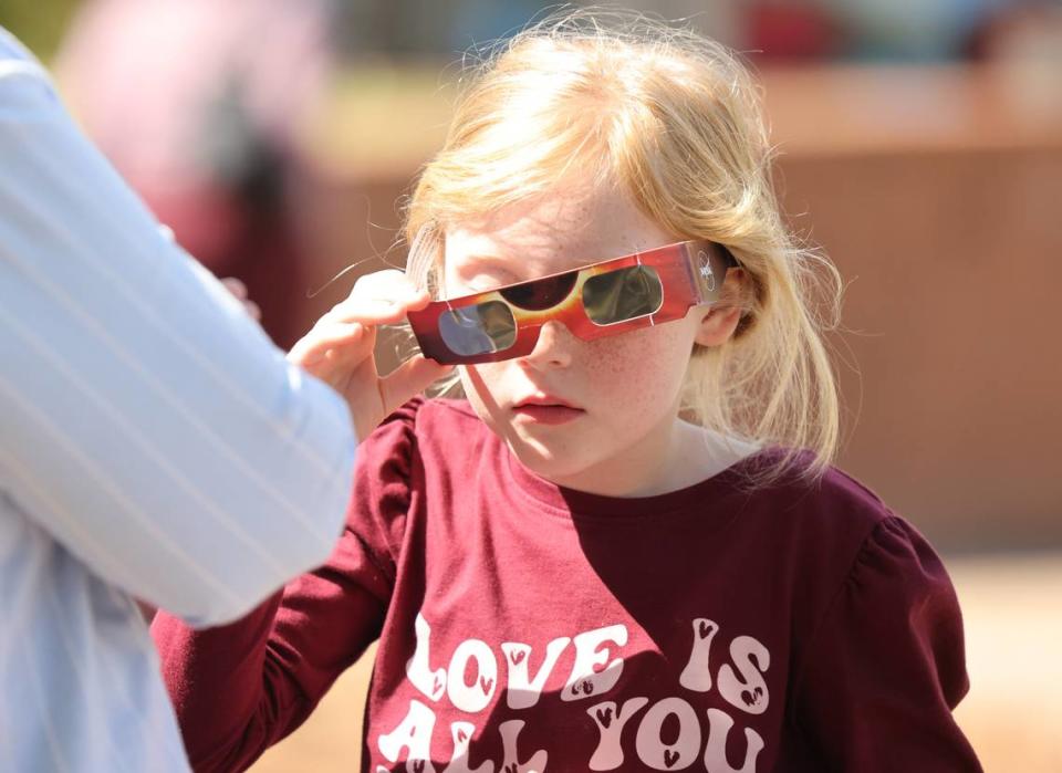 Aliyah Patterson puts on her special solar eclipse glasses Monday at the Old Town Amphitheather in downtown Rock Hill.