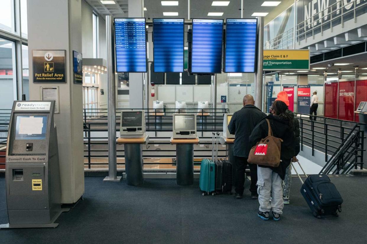 NEW YORK, NY - DECEMBER 24: Travelers move through the departures hall at Terminal 2 of John F. Kennedy International Airport on December 24, 2021 in New York City. Thousands of travelers were left stranded across the country after multiple airlines cancelled Christmas Eve flights Friday due to rising Omicron variant cases of COVID-19, staffing shortages and severe weather.   Scott Heins/Getty Images/AFP (Photo by Scott Heins / GETTY IMAGES NORTH AMERICA / Getty Images via AFP)