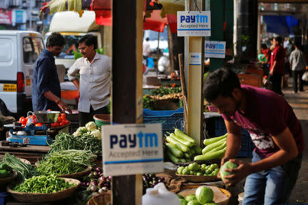 Advertisement boards of Paytm, a digital wallet company, are seen placed at stalls of roadside vegetable vendors as they wait for customers in Mumbai, India, November 19, 2016. REUTERS/Shailesh Andrade