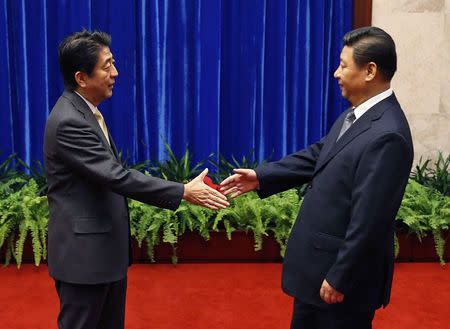 Japan&#39;s Prime Minister Shinzo Abe shakes hands with China&#39;s President Xi Jinping (R) during their meeting at the Great Hall of the People, on the sidelines of the Asia Pacific Economic Cooperation (APEC) meetings, in Beijing November 10, 2014. REUTERS/Kim Kyung-Hoon