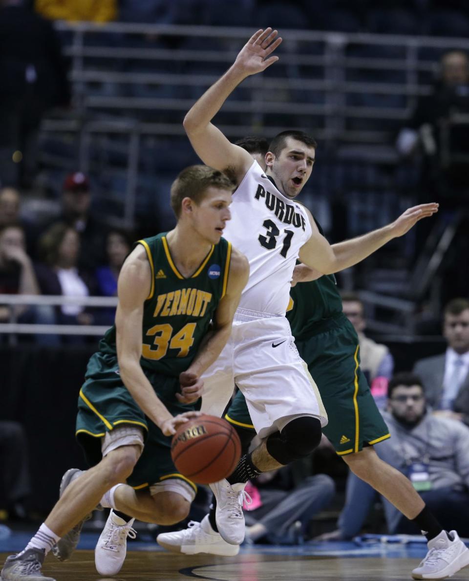 Vermont's Kurt Steidl drives past Purdue's Dakota Mathias during the first half of an NCAA college basketball tournament first round game Thursday, March 16, 2017, in Milwaukee. (AP Photo/Kiichiro Sato)