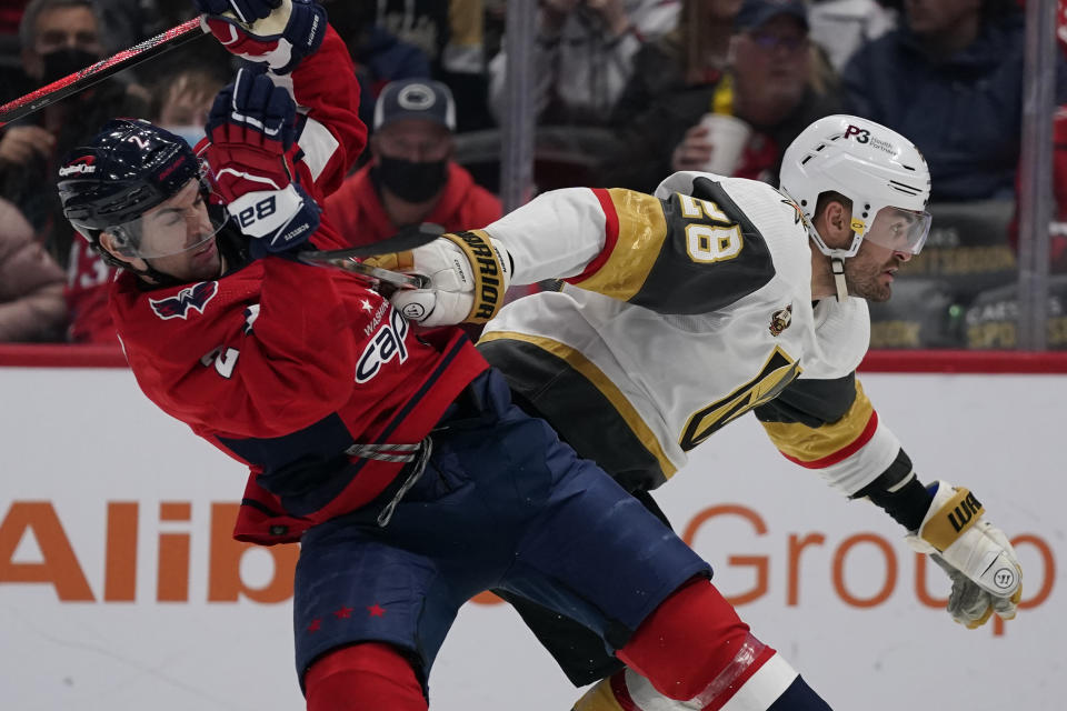 Vegas Golden Knights left wing William Carrier (28) fights for position against Washington Capitals defenseman Justin Schultz during the first period of an NHL hockey game, Monday, Jan. 24, 2022, in Washington. (AP Photo/Evan Vucci)