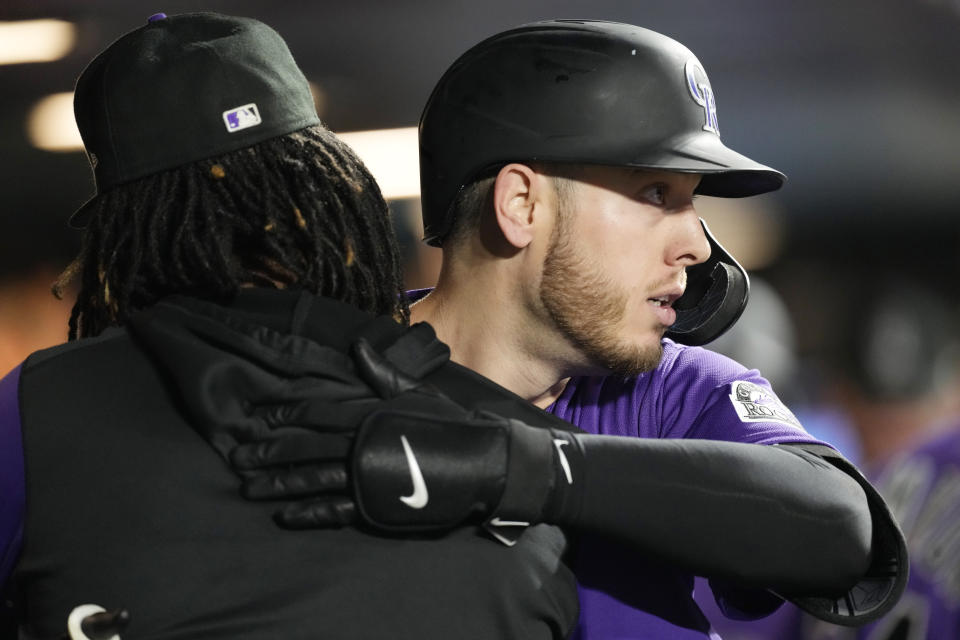 Colorado Rockies' Jose Urena, left, hugs C.J. Cron as he returns to the dugout after hitting a three-run home run off Texas Rangers relief pitcher Brock Burke in the seventh inning of a baseball game Tuesday, Aug. 23, 2022, in Denver. (AP Photo/David Zalubowski)