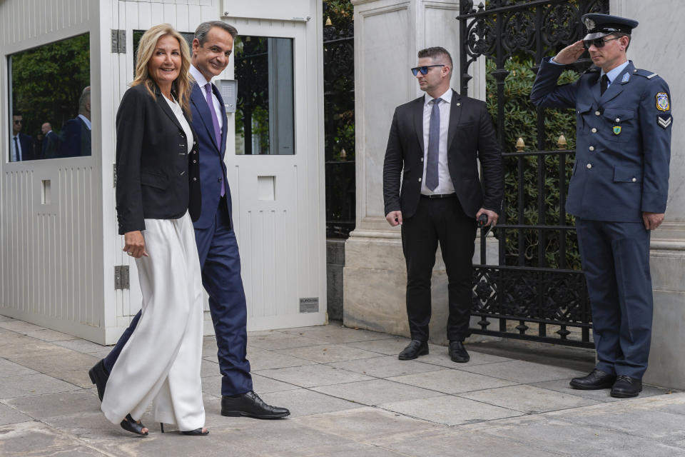 Greece's Prime Minister Kyriakos Mitsotakis, second left, arrives with his wife Mareva Grabowski-Mitsotakis to take the oath at the Presidential Palace, in Athens, Greece, Monday, June 26, 2023. Greece's center-right leader Kyriakos Mitsotakis received the mandate to form a new government Monday after easily winning a second term with a record-high margin over the leftwing opposition, in an election that also ushered new far-right parties into Parliament. (AP Photo/Petros Giannakouris)
