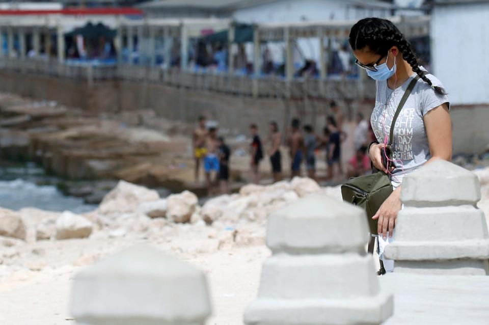 A woman wearing a protective face mask to prevent the spread of the coronavirus disease (COVID-19) walks along the Mediterranean Sea, as the government closes beaches in Alexandria, Egypt, August 7, 2020. REUTERS/Amr Abdallah Dalsh