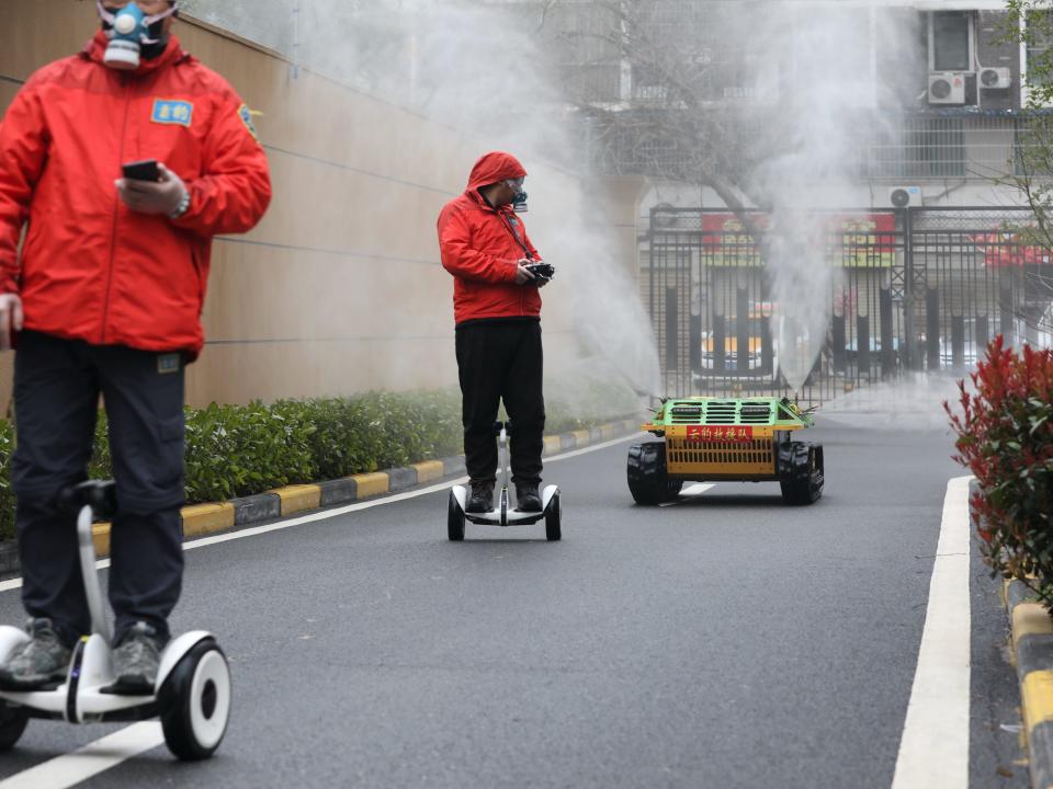 Workers with protective face masks on ride smart self balancing scooters_chinadaily via reuters.JPG