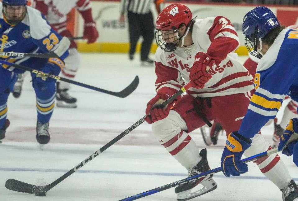 Wisconsin forward Sam Stange (3) controls the puck while Lake Superior State forward Connor Milburn (9) and defenseman Artyom Borshyov defend during the Kwik Trip Face-Off Tournament Dec. 28 at Fiserv Forum in Milwaukee.