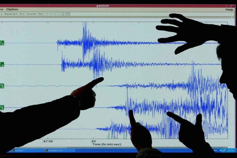 Staff at the British Geological Survey in Edinburgh look at a graph showing the earthquake that occurred at Market Rasen in north-east Lincolnshire in 2008 (Jeff J Mitchell/Getty Images)