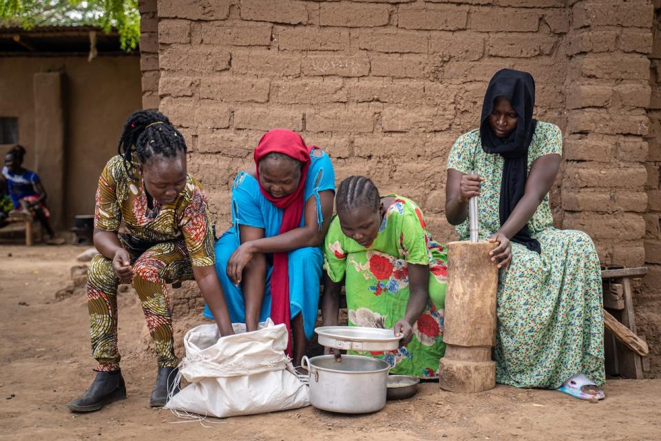 Patricia Kamssor, far left, prepares okra for eating with the women she lived with at their home in the Kakuma refugee camp. 