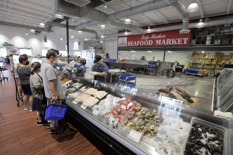 Customers wait for service as they make their selections from the fresh seafood in the Safe Harbor Seafood Market in Mayport, Fla., Wednesday, June 23, 2021.