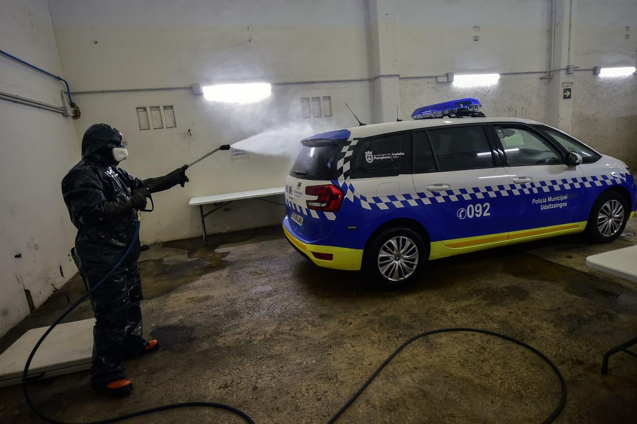 Volunteer worker of Search and Rescue (SAR) with special equipment, disinfects a police car at Local Police station to prevent the spread of coronavirus COVID-19, in Pamplona, northern Spain, on Sunday, March 22, 2020.