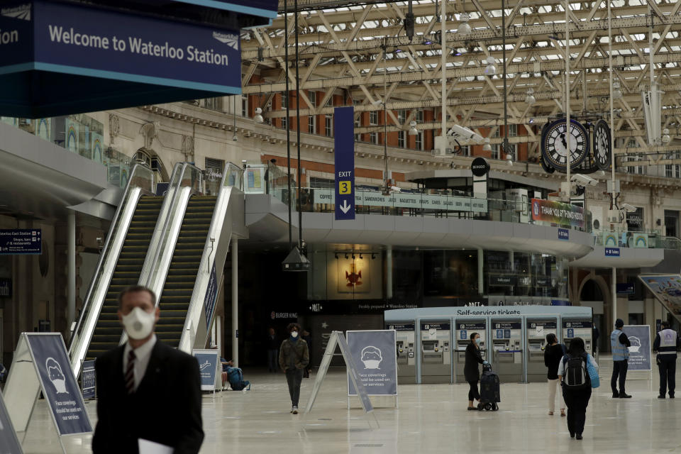 Signs recommending people wear face coverings to help stop the spread of coronavirus are displayed in Waterloo station, London, Thursday, June 4, 2020. Waterloo station, which is wide recognised as the busiest train station in Britain, is still much quieter than normal as most commuters are working from home and not commuting into central London offices. (AP Photo/Matt Dunham)