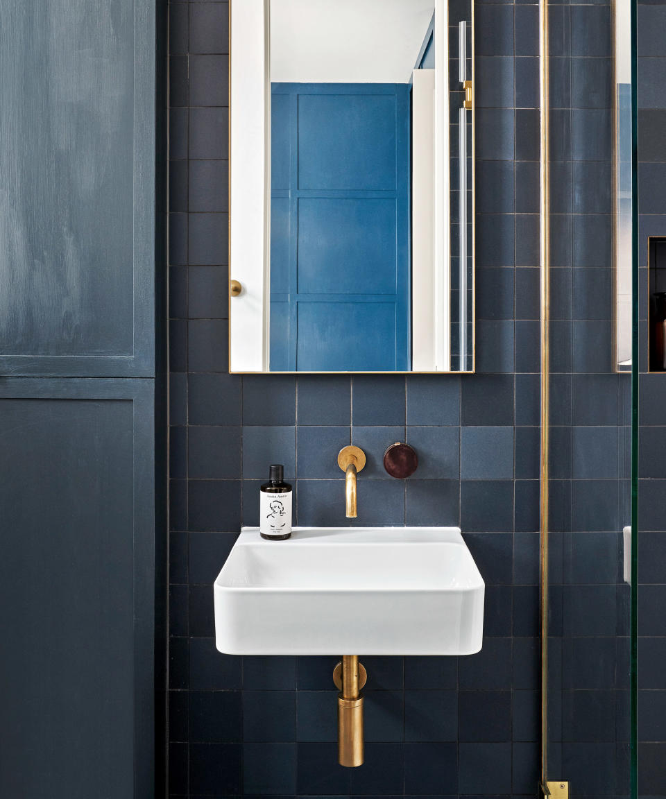 bathroom with gold fittings on the sink and shower